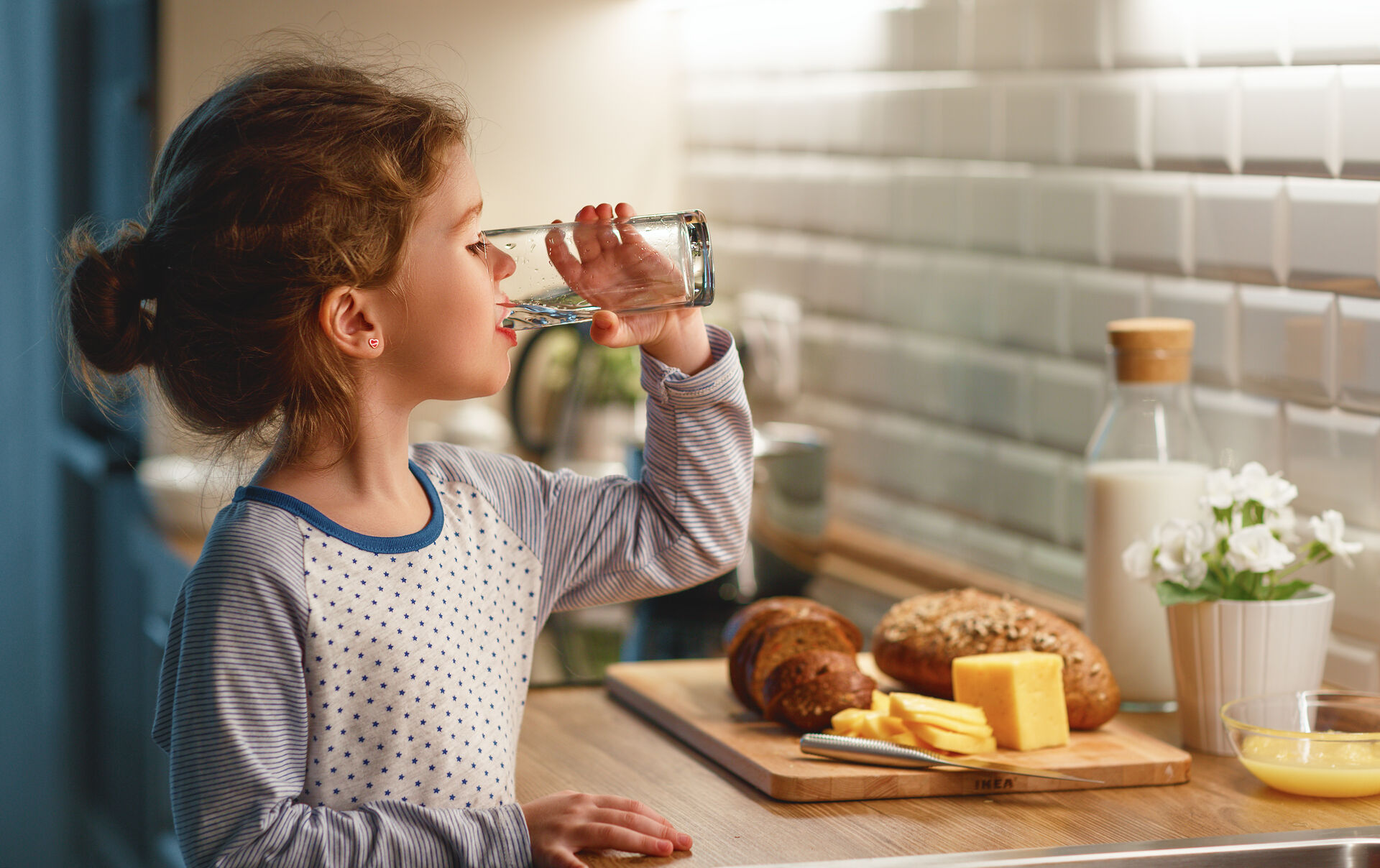 Girl drinking clean water in kitchen