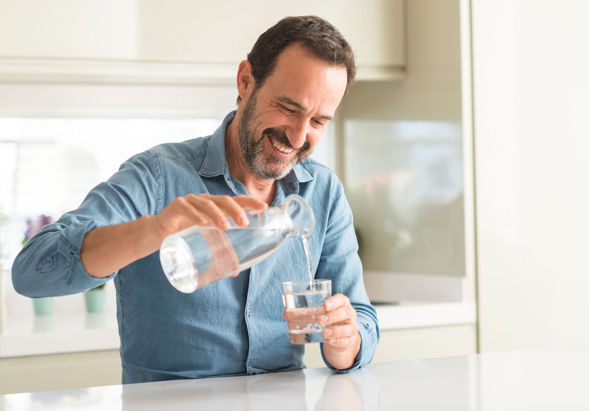 Man pouring a glass of clean filtered water